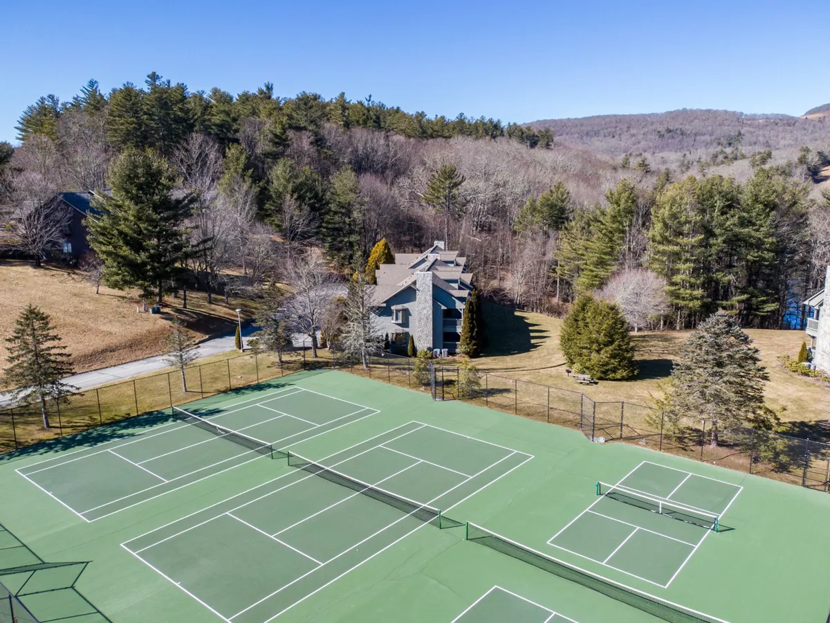 The resort’s tennis courts are encircled by mature trees and situated near property buildings, offering an active outdoor environment. The courts are well-maintained, inviting guests to participate in friendly matches or group events while surrounded by scenic greenery.
