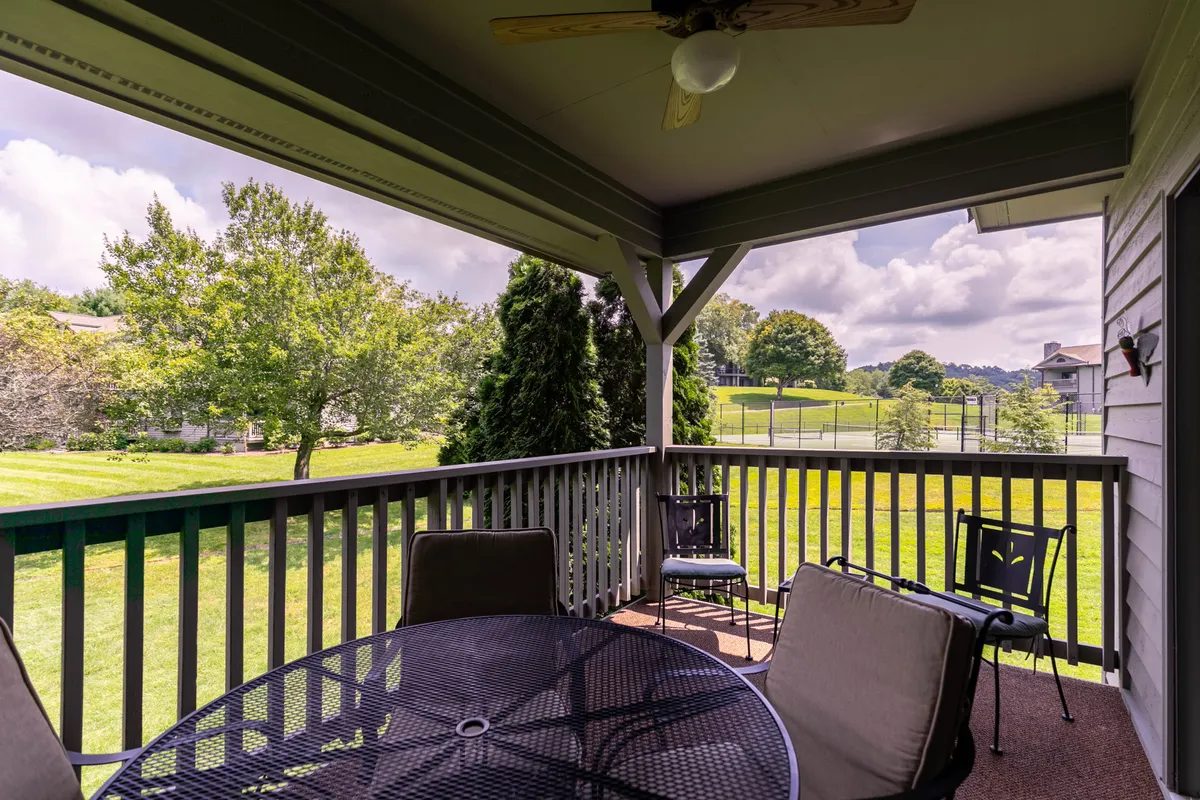 A tranquil exterior seating area with a table set on a green lawn, surrounded by trees. It suggests a comfortable spot for outdoor family gatherings, meals, or relaxing after a day of activities.